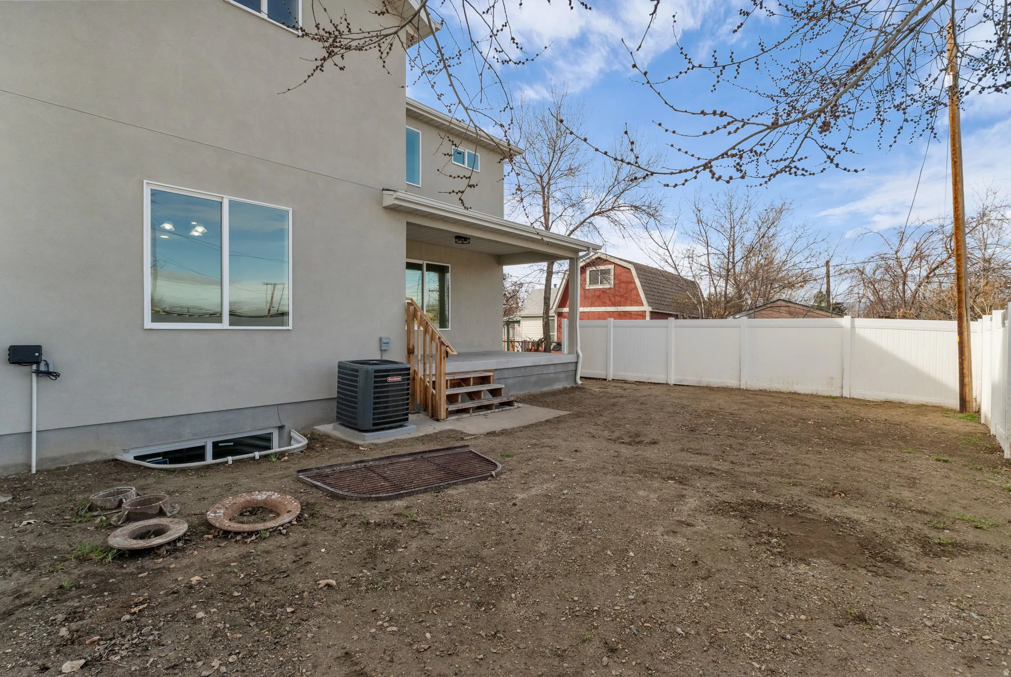 Back of house featuring a fenced backyard, stucco siding, and a porch