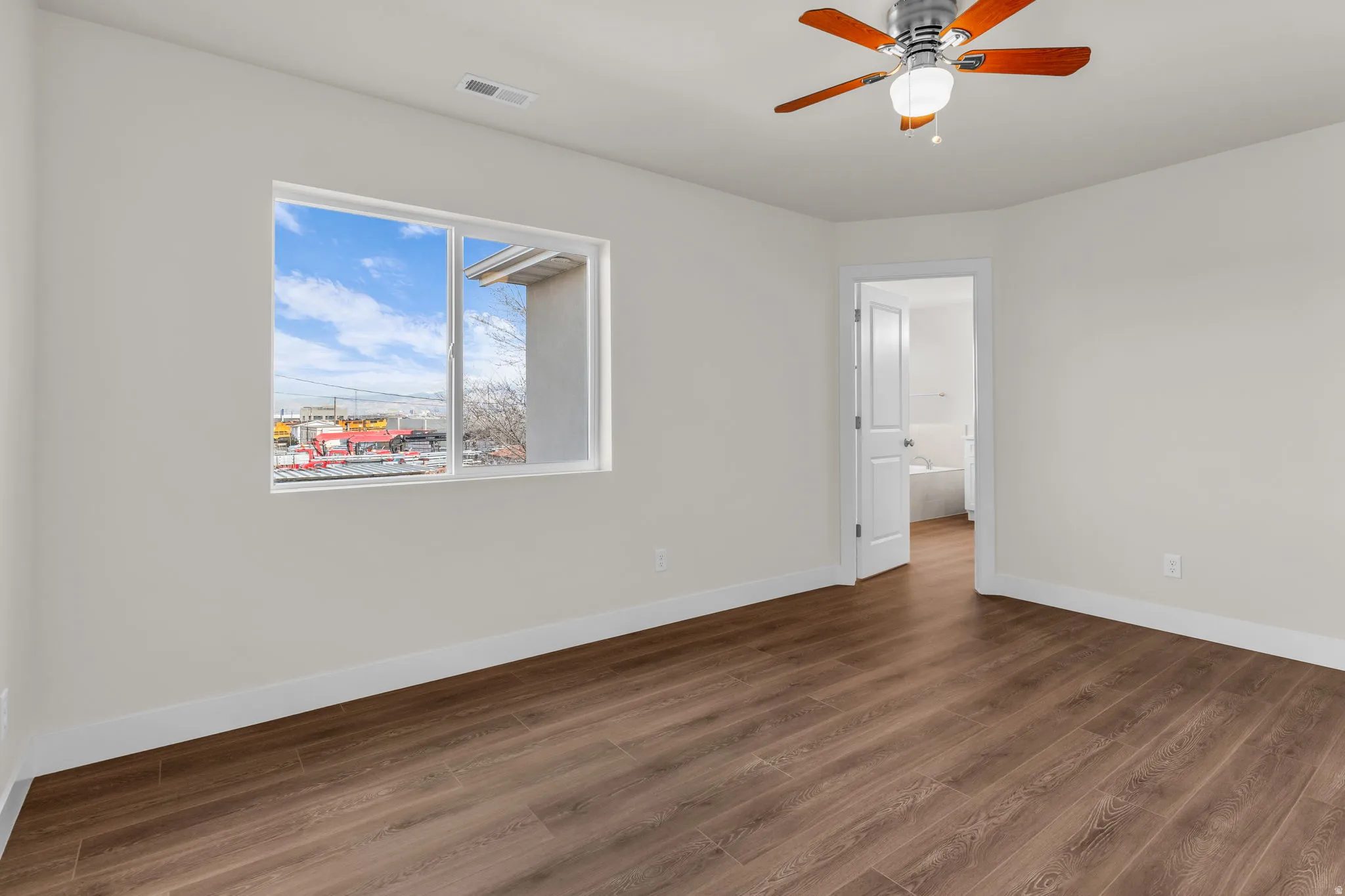 Spare room featuring dark wood-type flooring and a ceiling fan