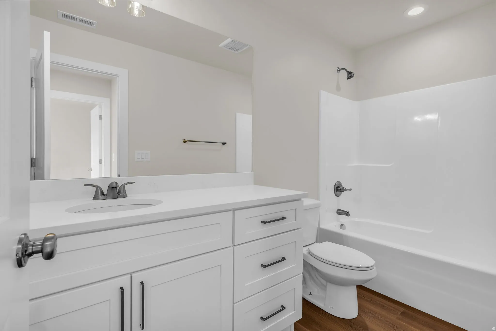 Full bathroom featuring shower / tub combination, vanity, and dark wood finished floors