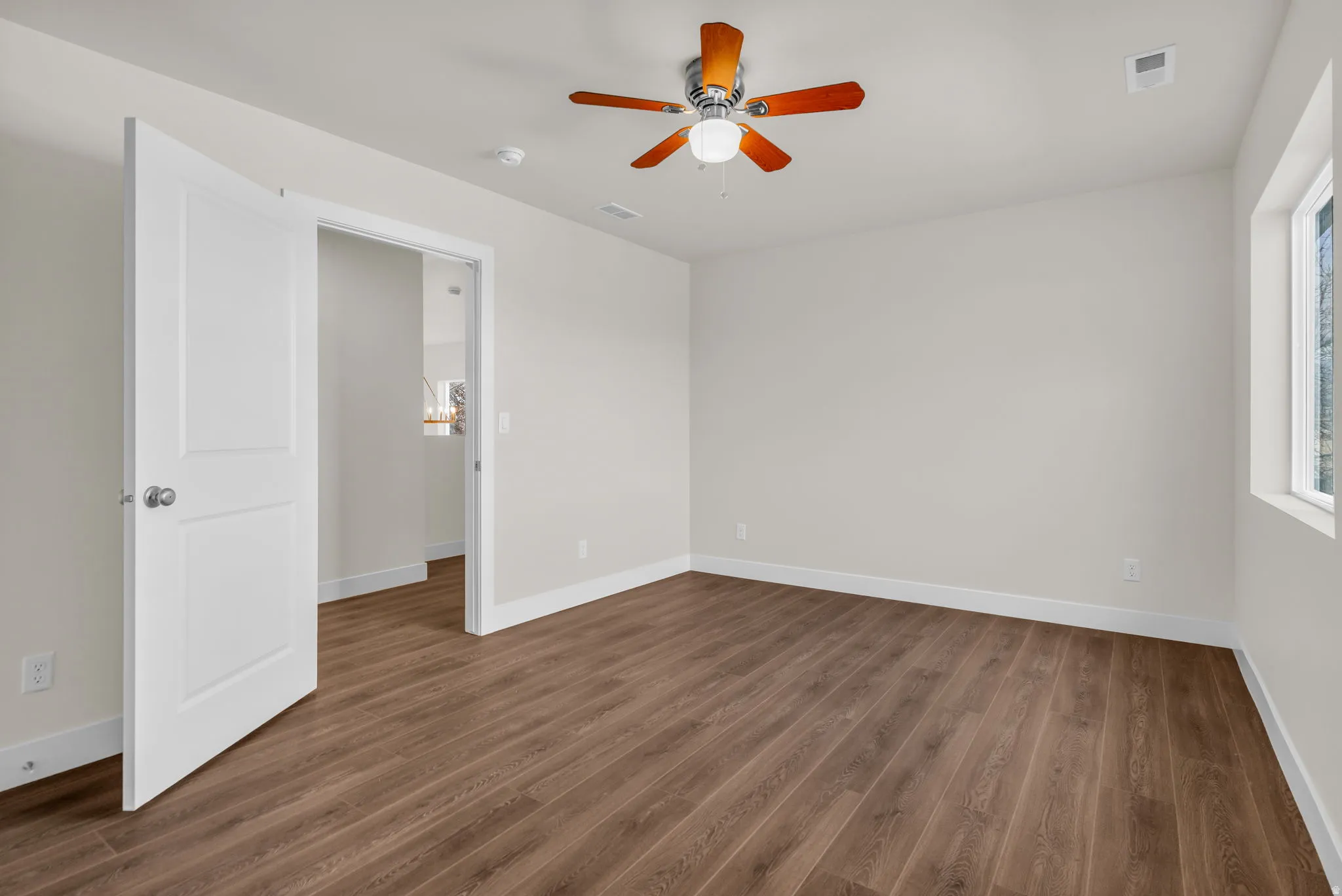 Empty room featuring ceiling fan and dark wood-style floors
