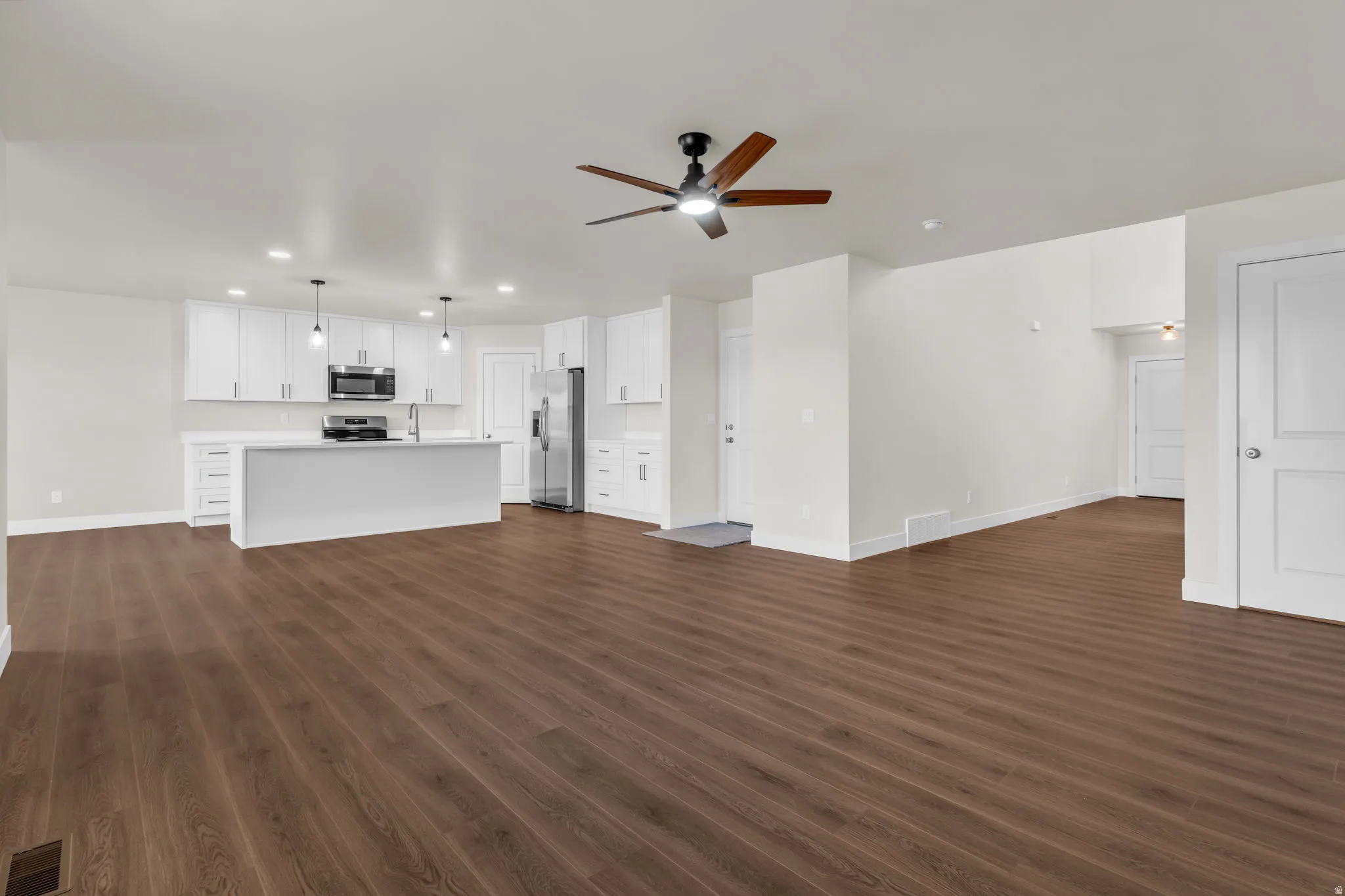 Unfurnished living room with recessed lighting, ceiling fan, and dark wood-style flooring