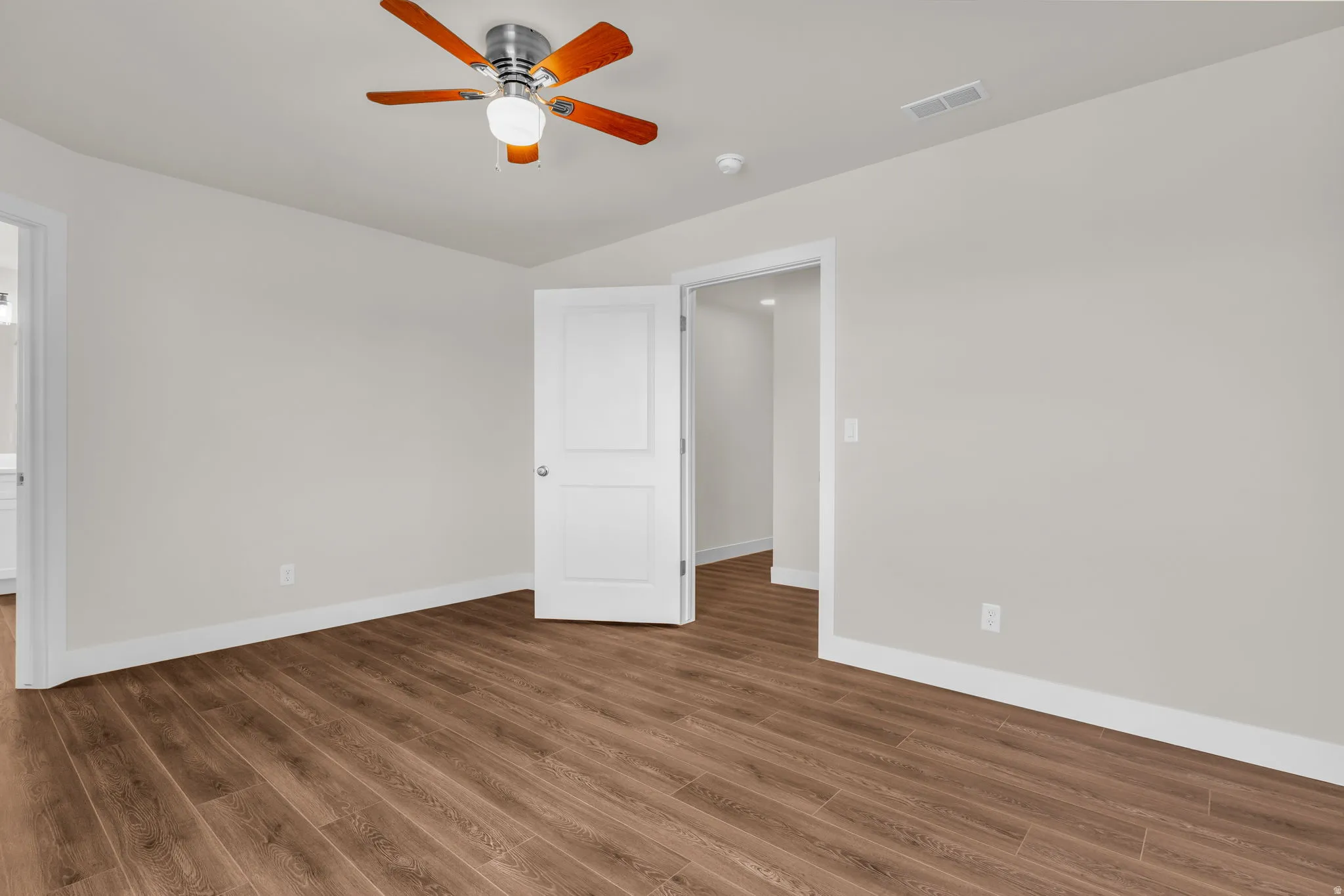 Unfurnished bedroom with wood finished floors and a ceiling fan