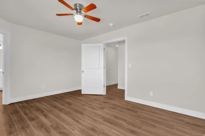 Unfurnished bedroom with wood finished floors and a ceiling fan
