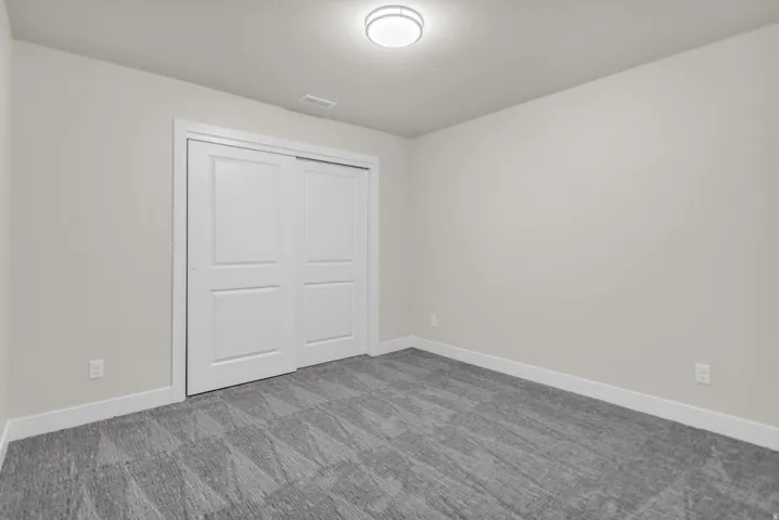 Unfurnished bedroom featuring a closet and carpet flooring