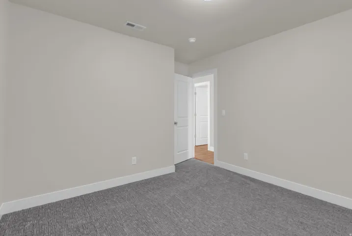 Empty room with carpet flooring and baseboards