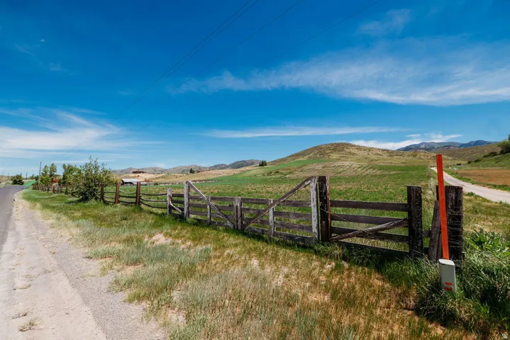 Expansive rural landscape featuring rolling green hills and a clear blue sky