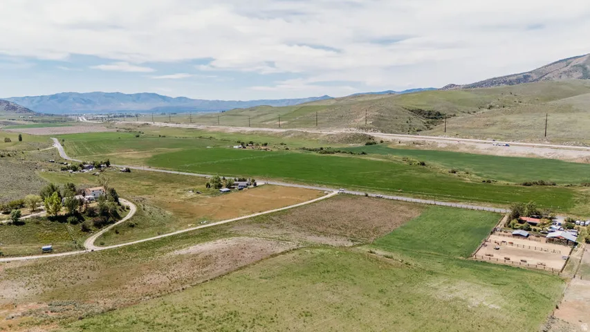 Expansive rural property featuring multiple pastures, a developed equestrian area with a riding arena and stables, and several residential structures