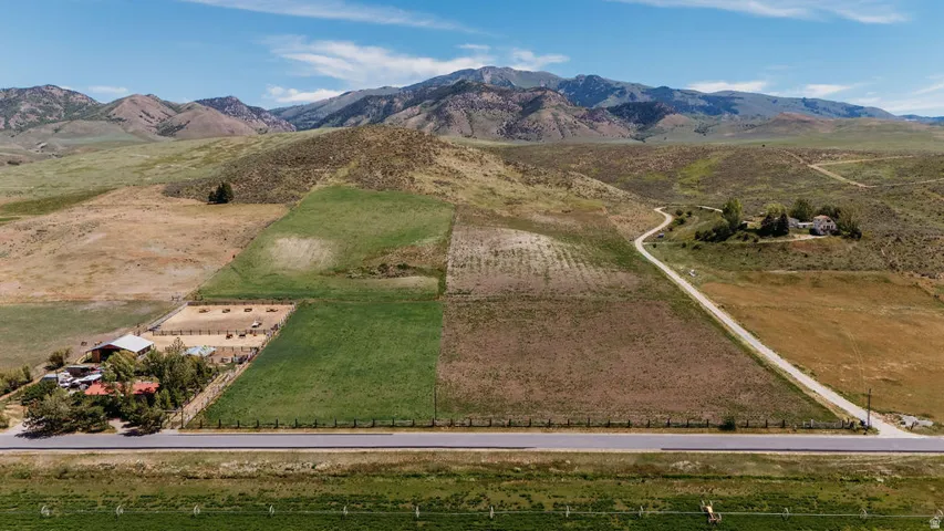 Expansive land parcel featuring multiple buildings, fenced areas, and varied topography