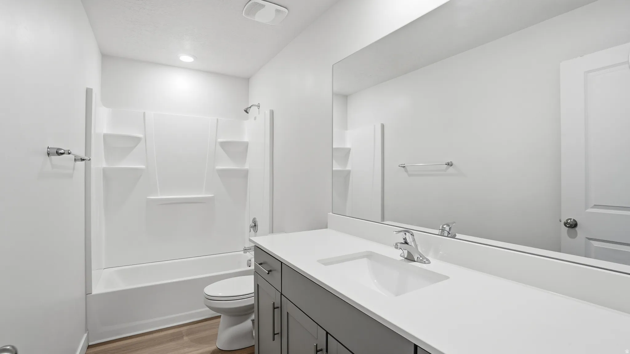 Full bathroom with vanity, light wood finished floors, and washtub / shower combination
