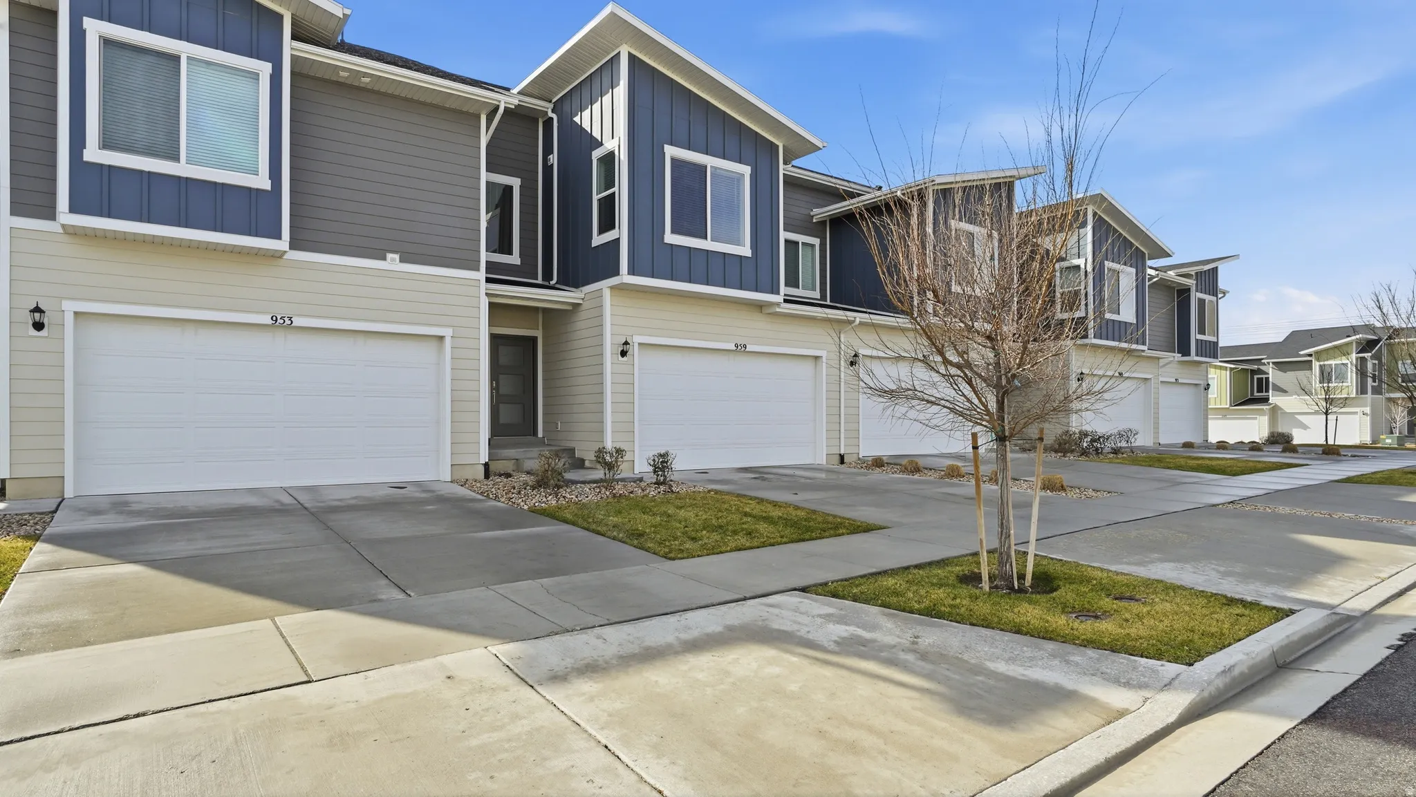Contemporary home with board and batten siding, driveway, an attached garage, and a residential view