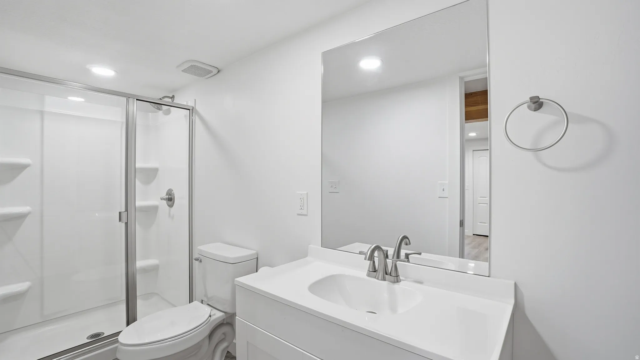 Full bathroom with vanity, a stall shower, and recessed lighting
