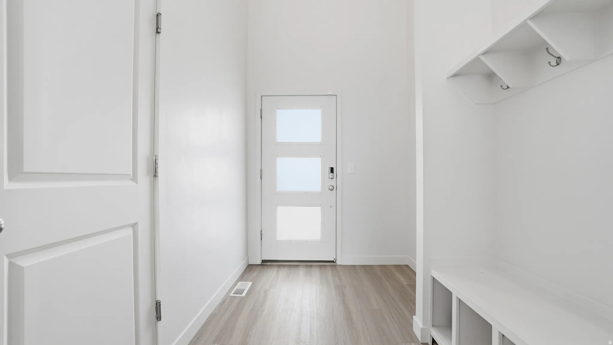 Mudroom with light wood-style flooring and baseboards