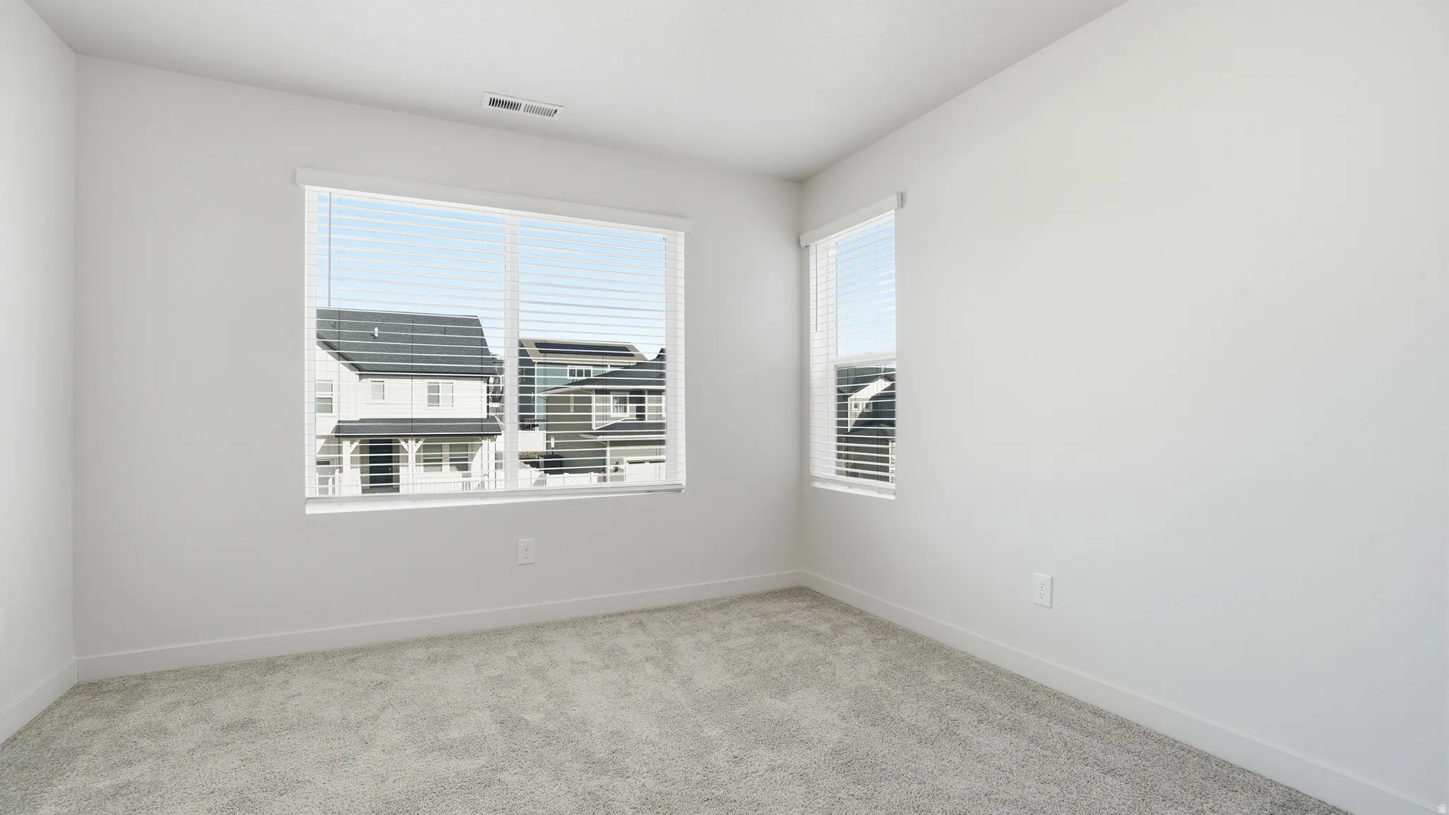 Spare room with light colored carpet and baseboards