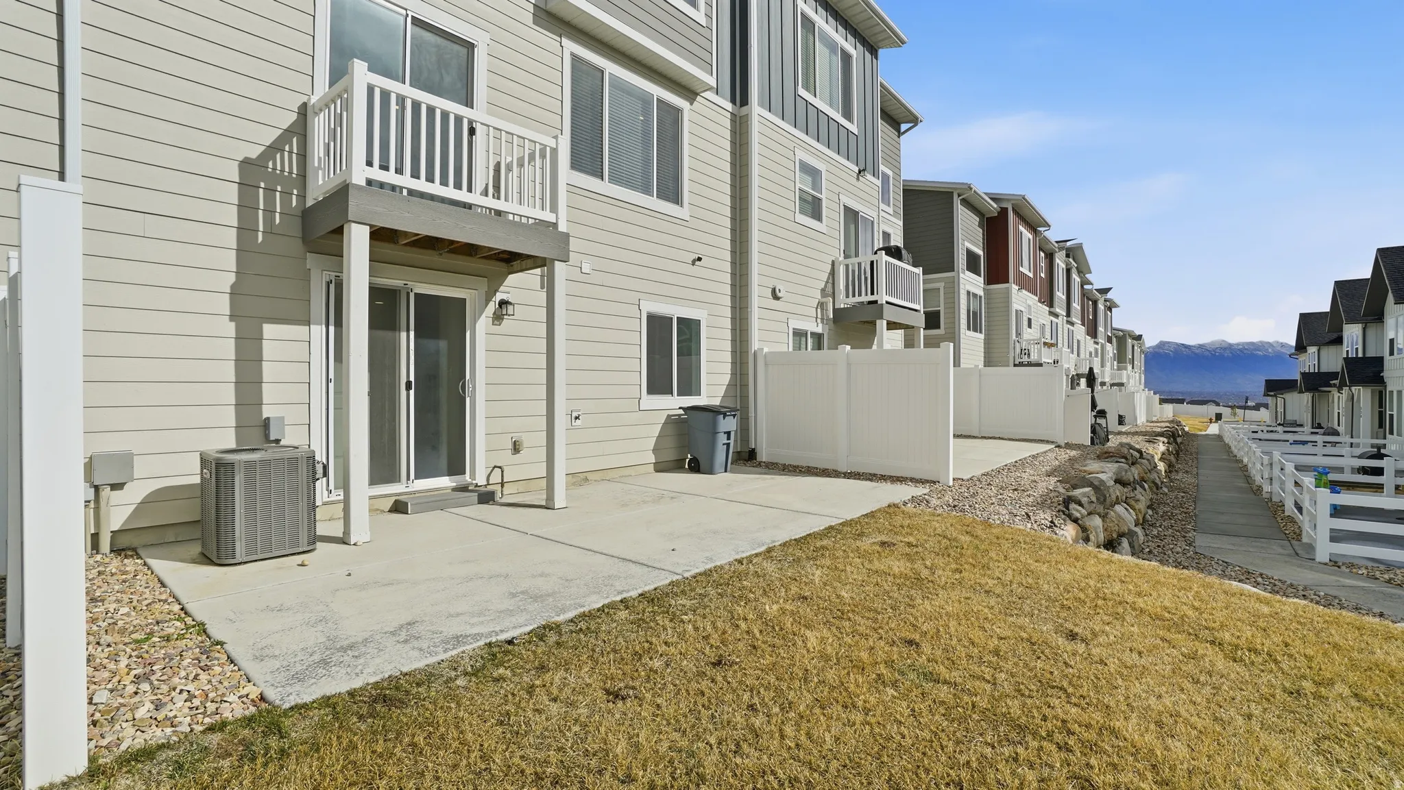 Rear view of house featuring a balcony, a patio area, a residential view, and a mountain view