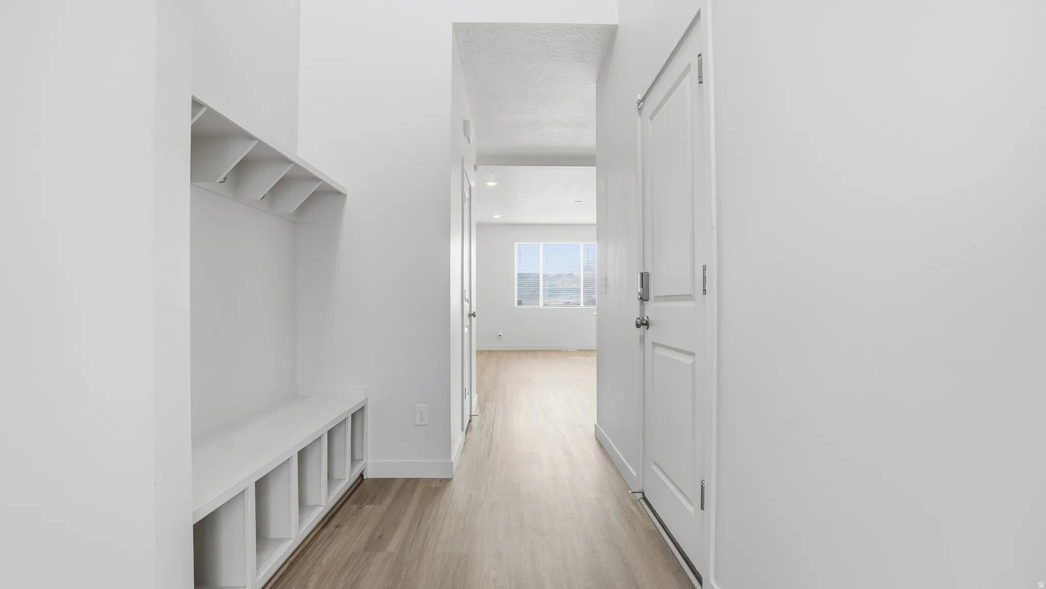 Mudroom featuring light wood-style floors and baseboards