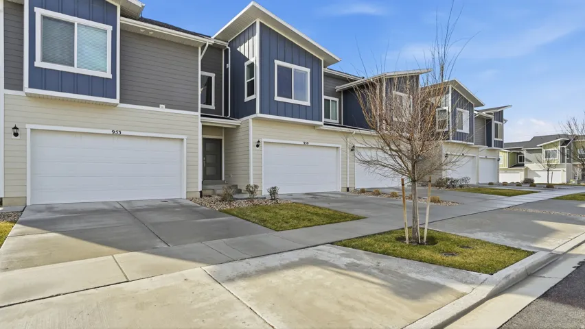 Contemporary home with board and batten siding, driveway, an attached garage, and a residential view