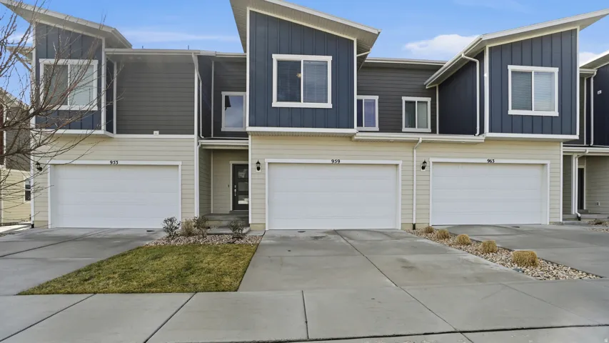 Modern home with driveway, board and batten siding, and an attached garage