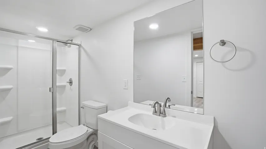 Full bathroom with vanity, a stall shower, and recessed lighting