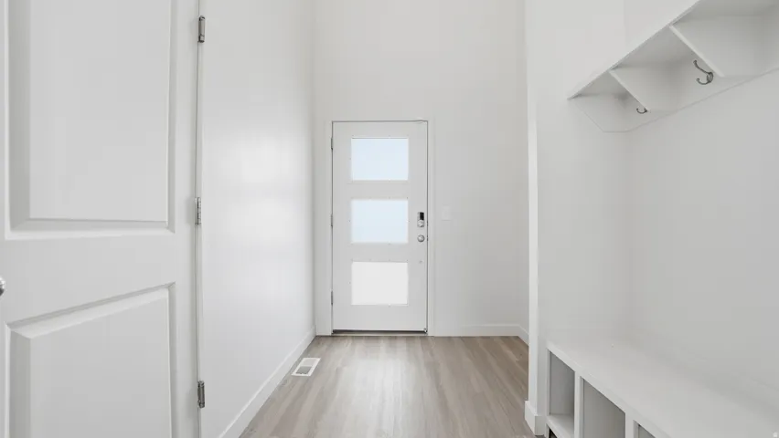 Mudroom with light wood-style flooring and baseboards