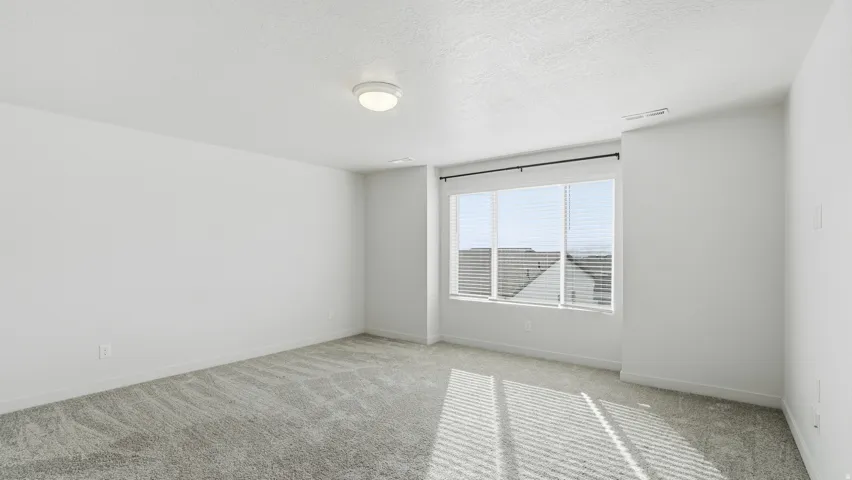 Carpeted empty room with baseboards and a textured ceiling