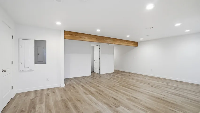 Unfurnished bedroom with recessed lighting, electric panel, and light wood finished floors