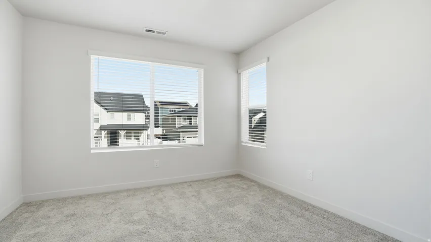 Spare room with light colored carpet and baseboards
