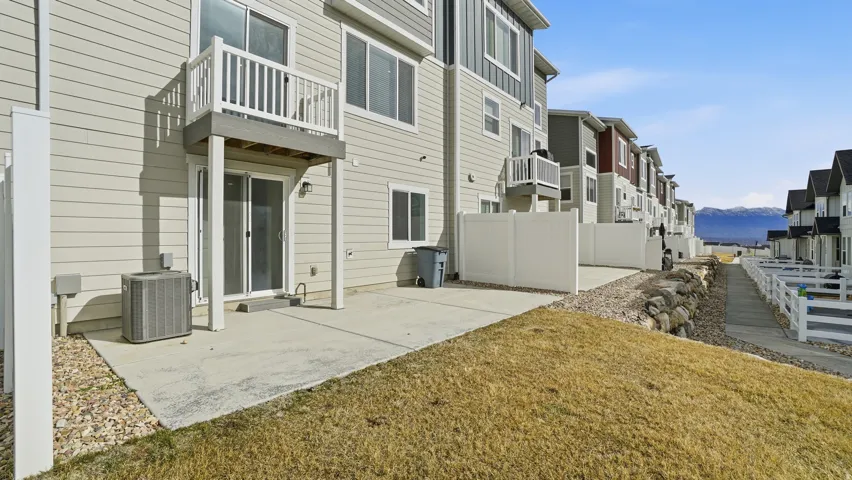 Rear view of house featuring a balcony, a patio area, a residential view, and a mountain view