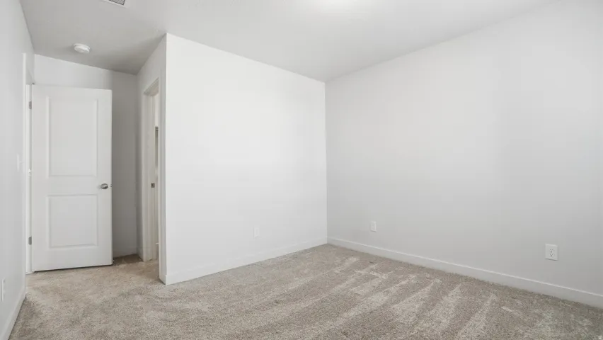 Spare room featuring light carpet and baseboards