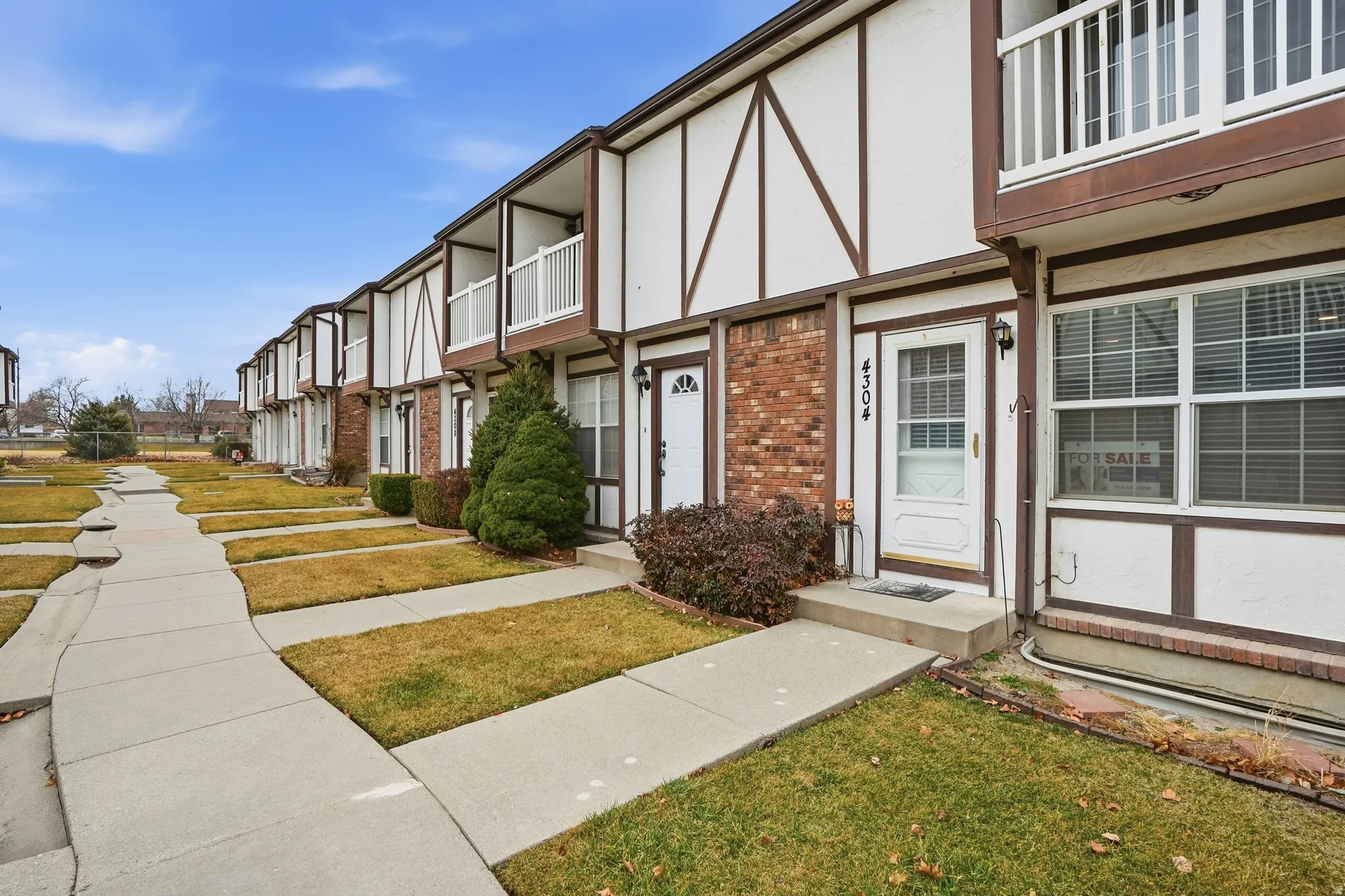 Entrance to property featuring brick siding, stucco siding, and a yard