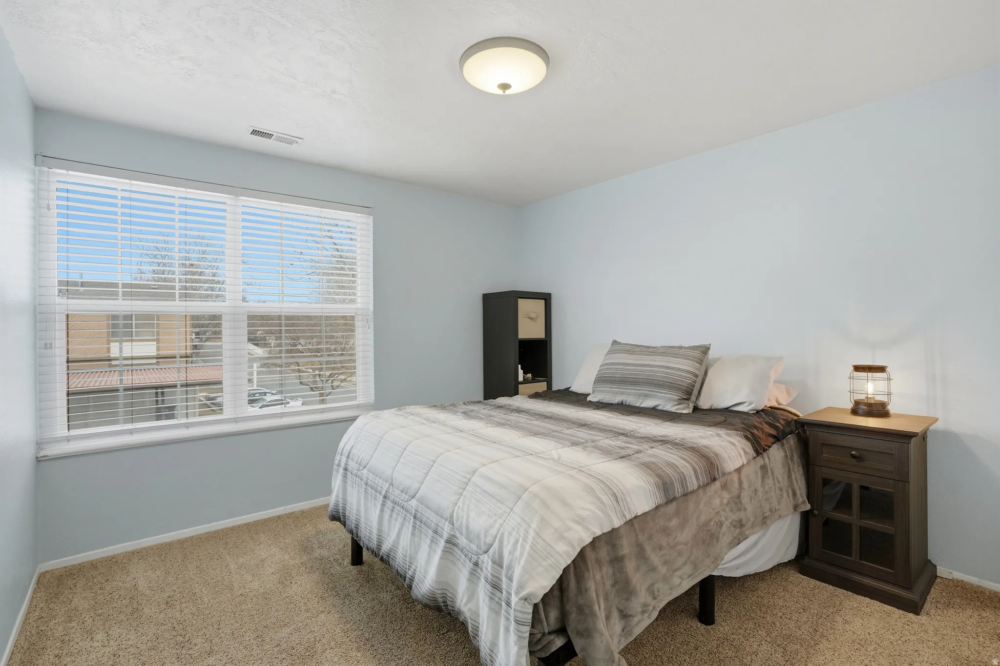 Bedroom featuring light carpet and baseboards