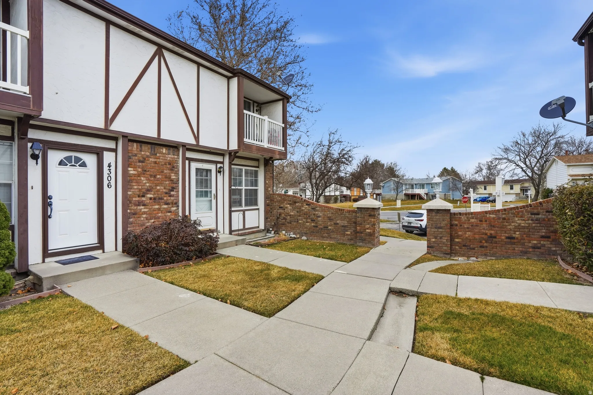 Entrance to property featuring stucco siding, brick siding, and a residential view