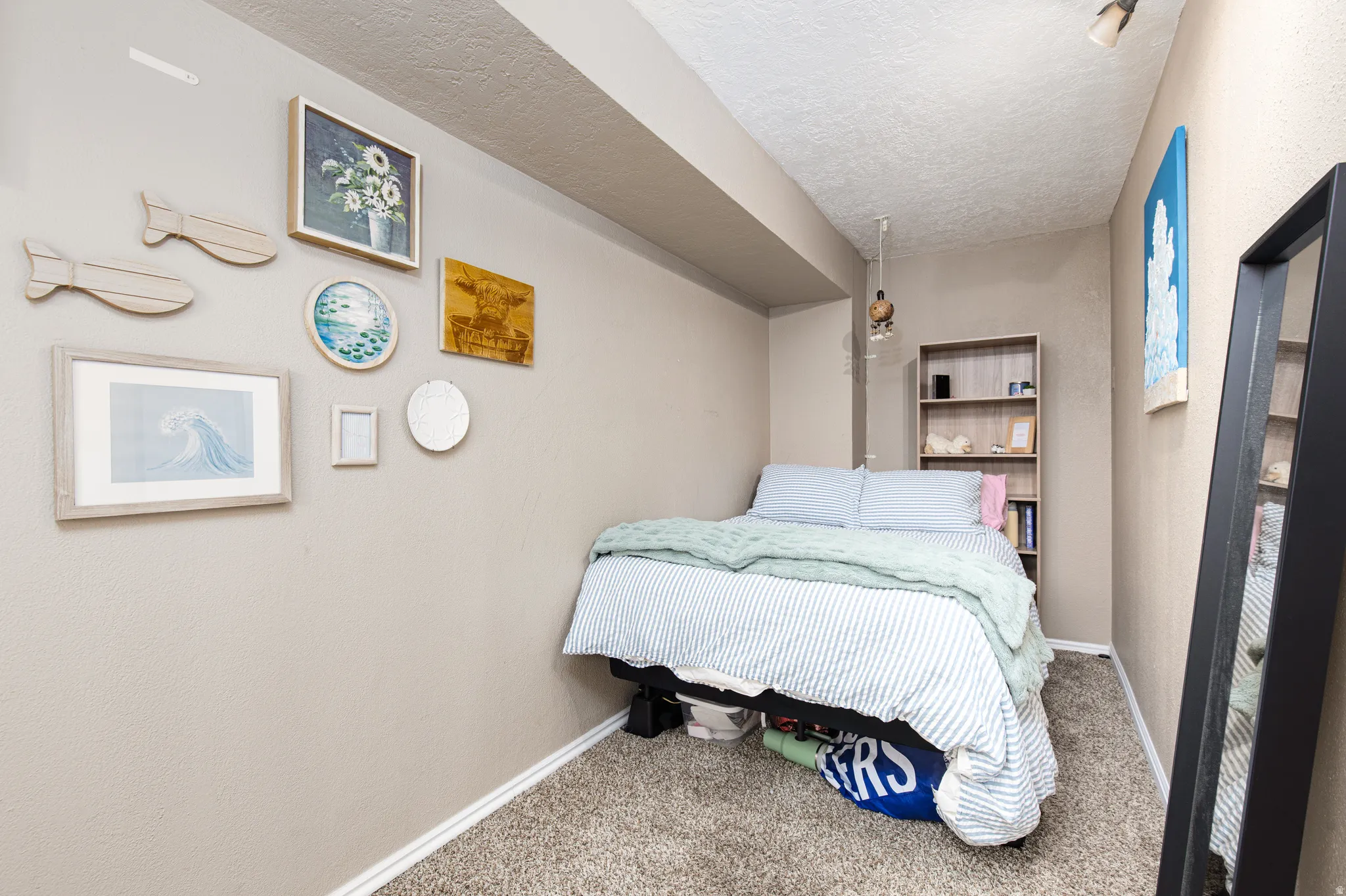Carpeted bedroom with baseboards and a textured ceiling