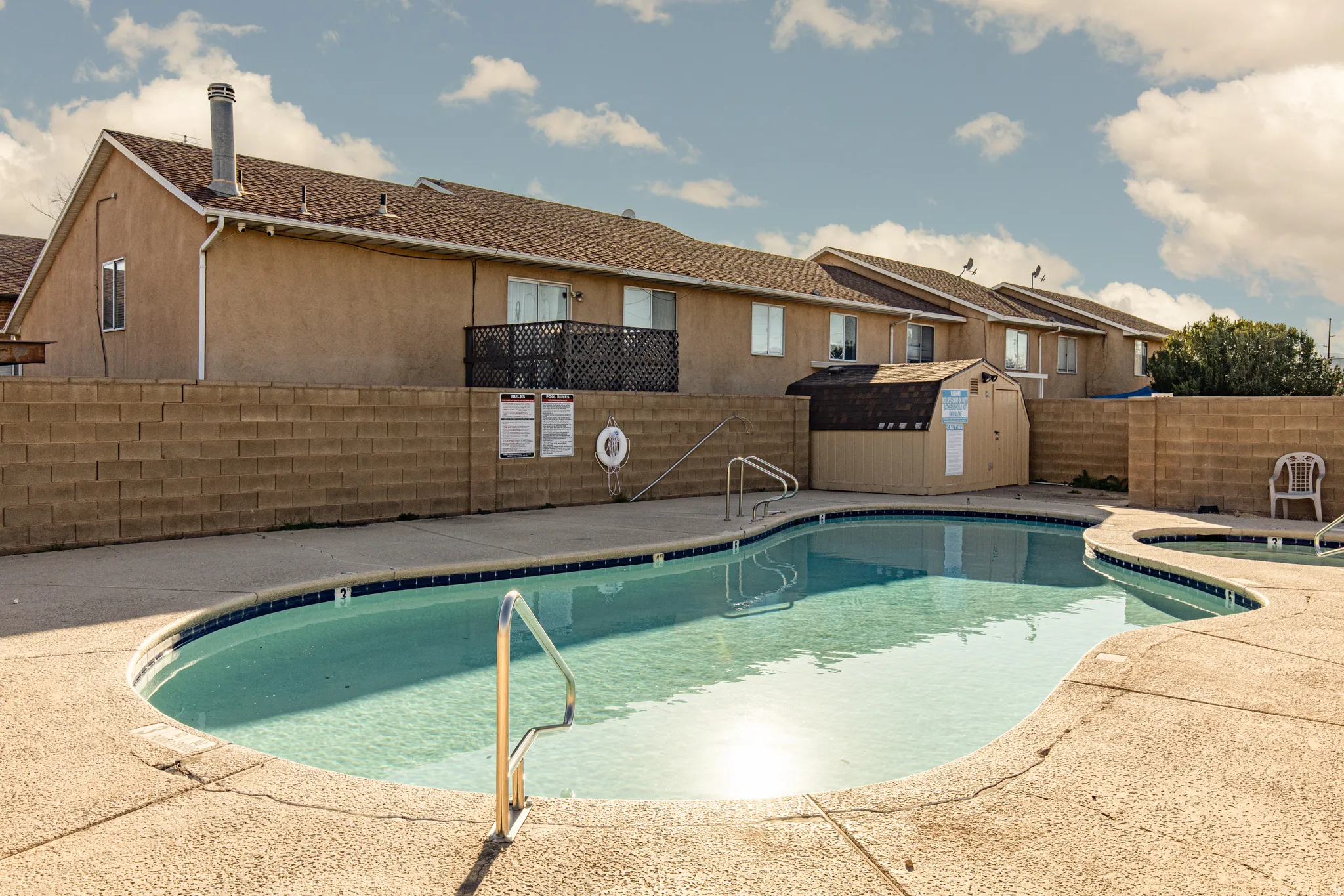 Community pool featuring a patio area, a fenced backyard, a storage shed, and a residential view