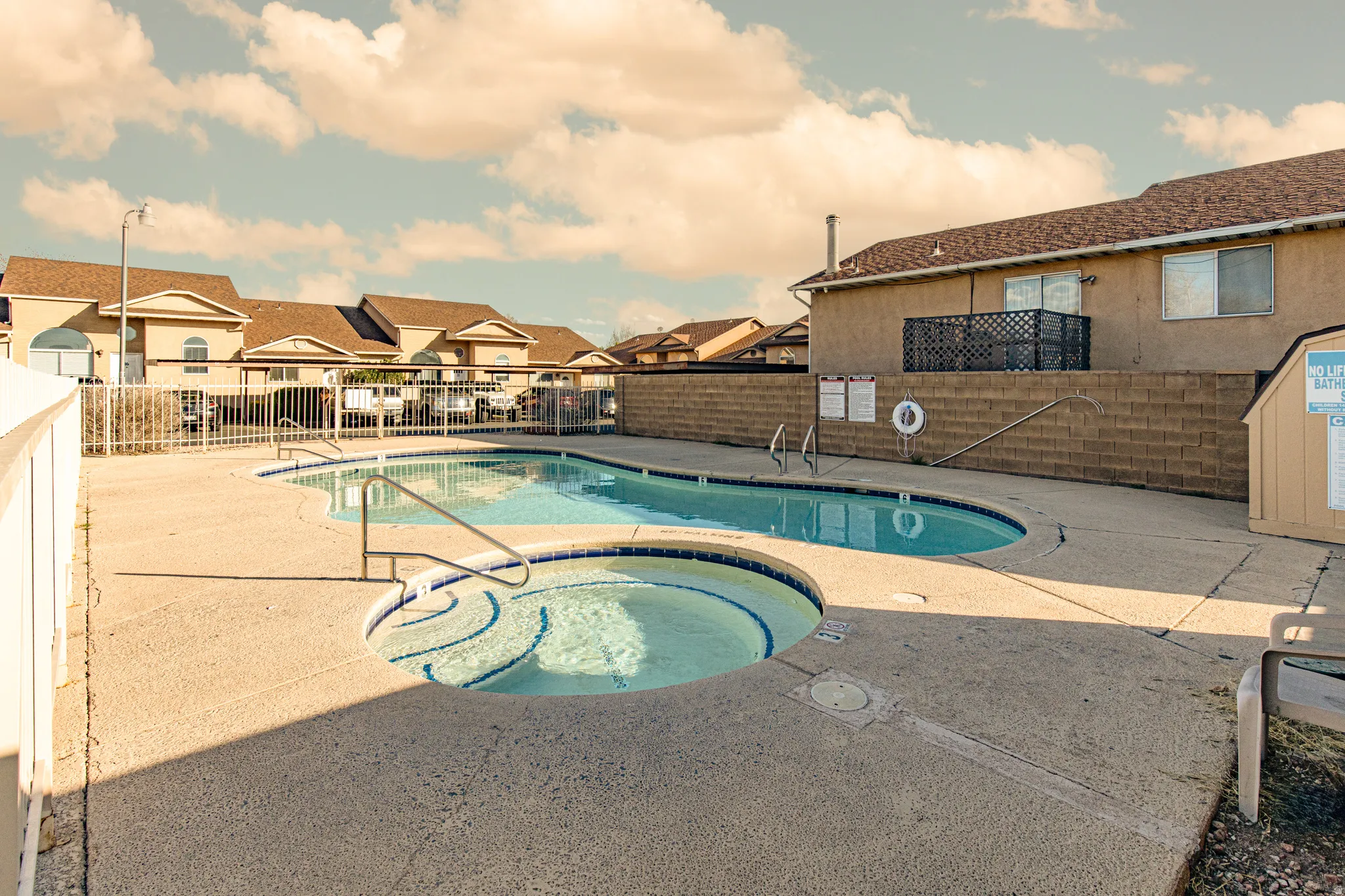 Community pool with a patio area, a residential view, and a hot tub