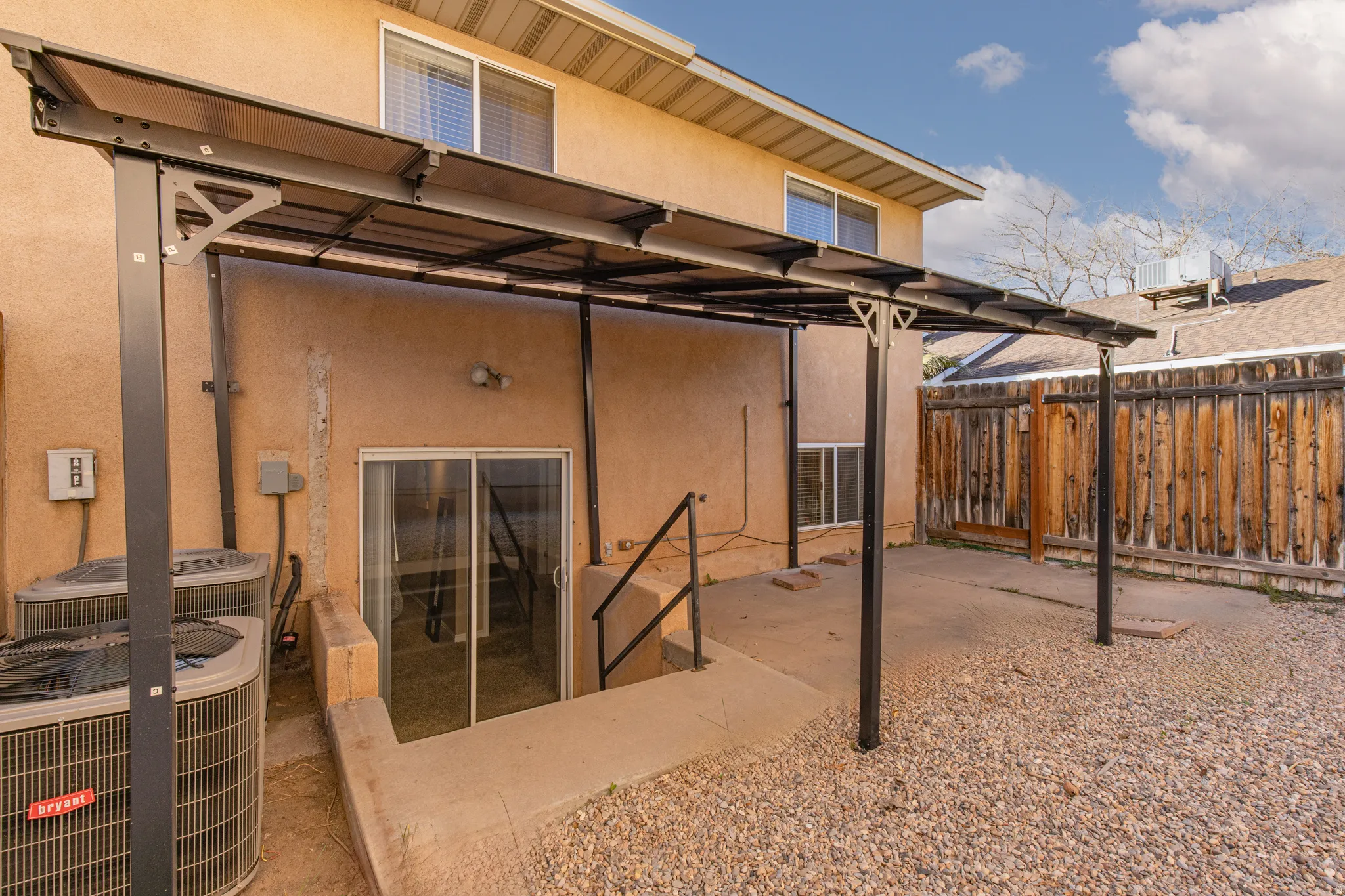 Back of house with a fenced backyard, stucco siding, and a patio area