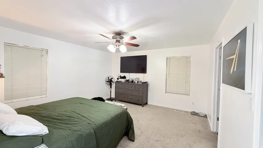 Recessed window, ceiling fan with integrated lighting, and carpeted flooring