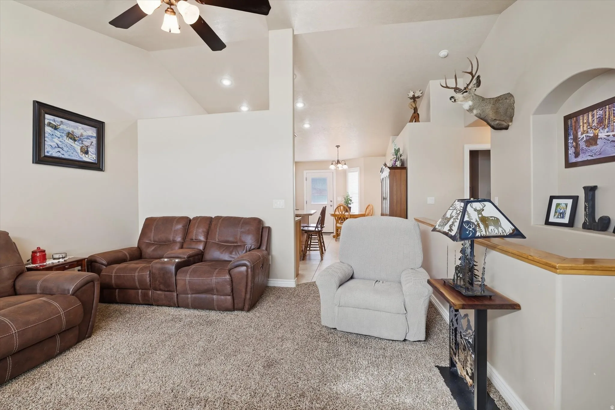 Carpeted living area with vaulted ceiling, ceiling fan, and recessed lighting