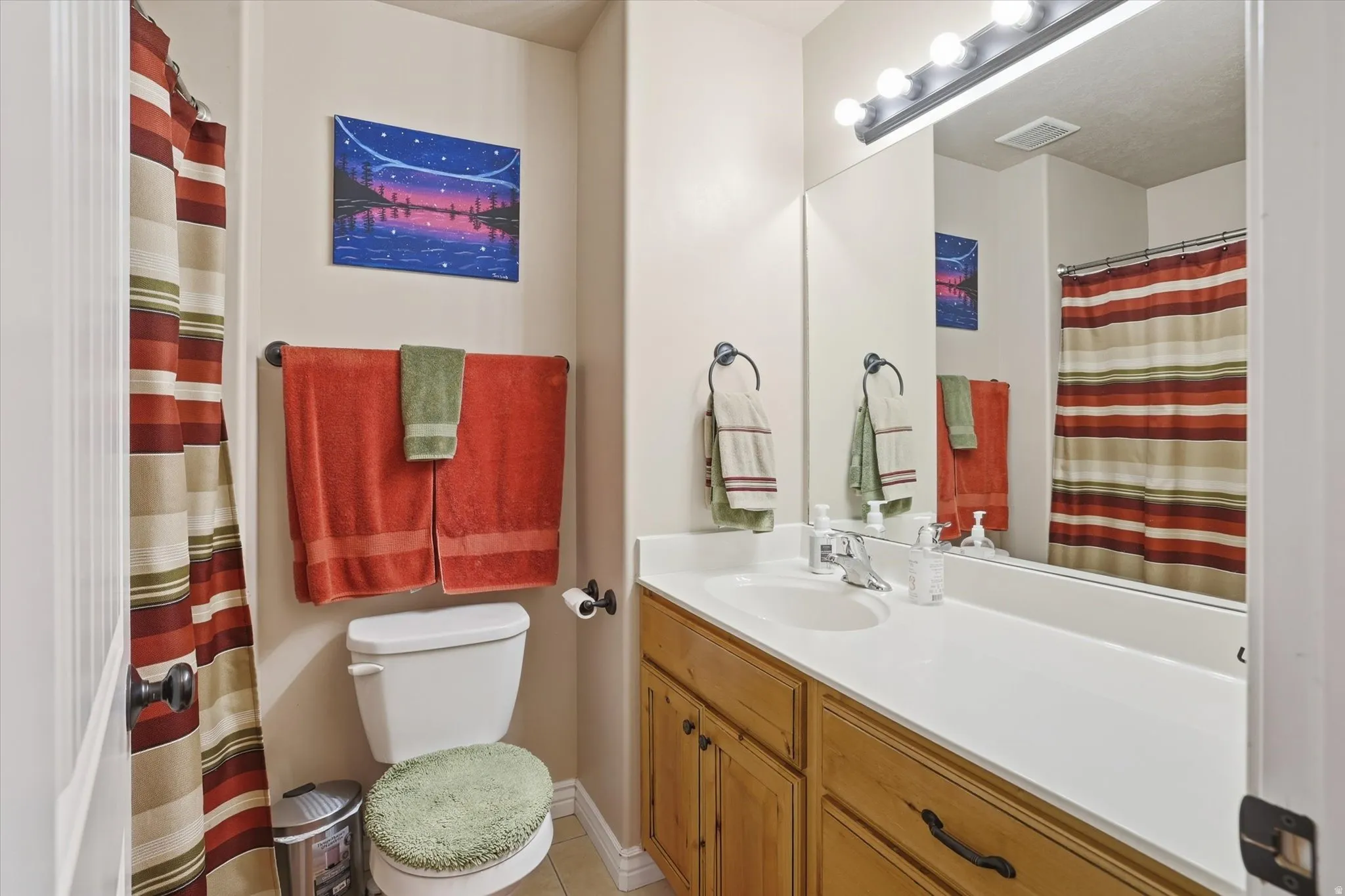 Full bath with vanity, a shower with shower curtain, and light tile patterned floors