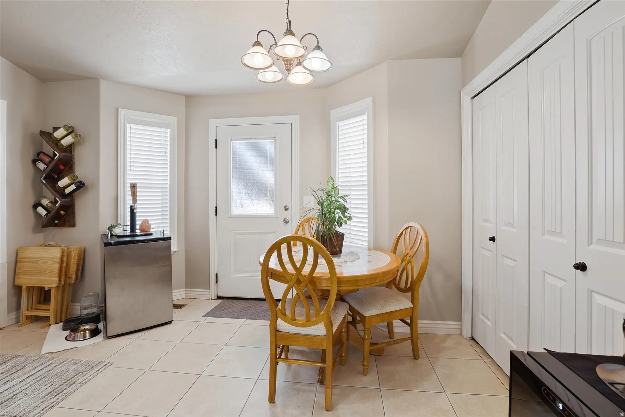 Dining room with a chandelier and light tile patterned floors