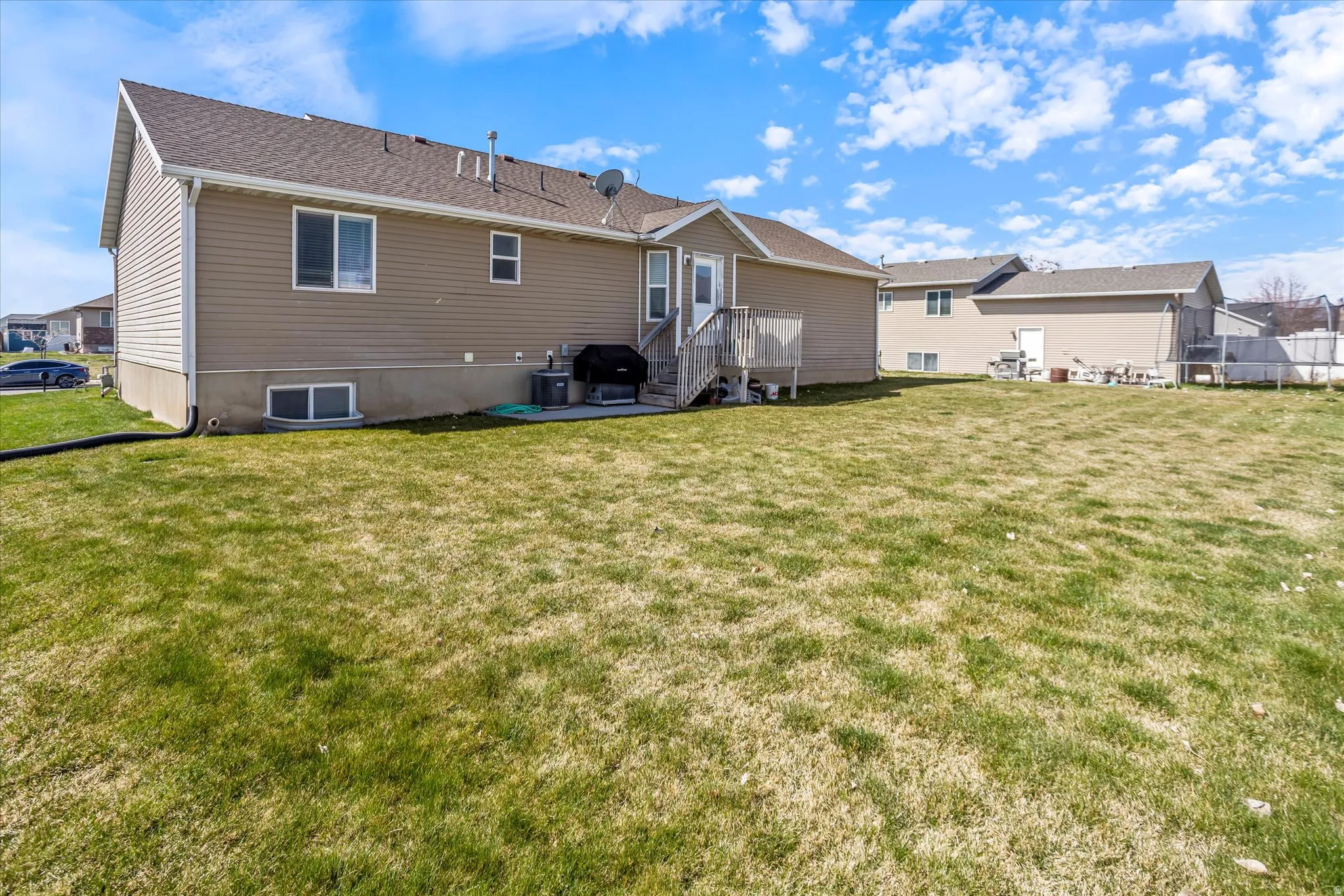 Rear view of house with a yard, a patio area, and a residential view