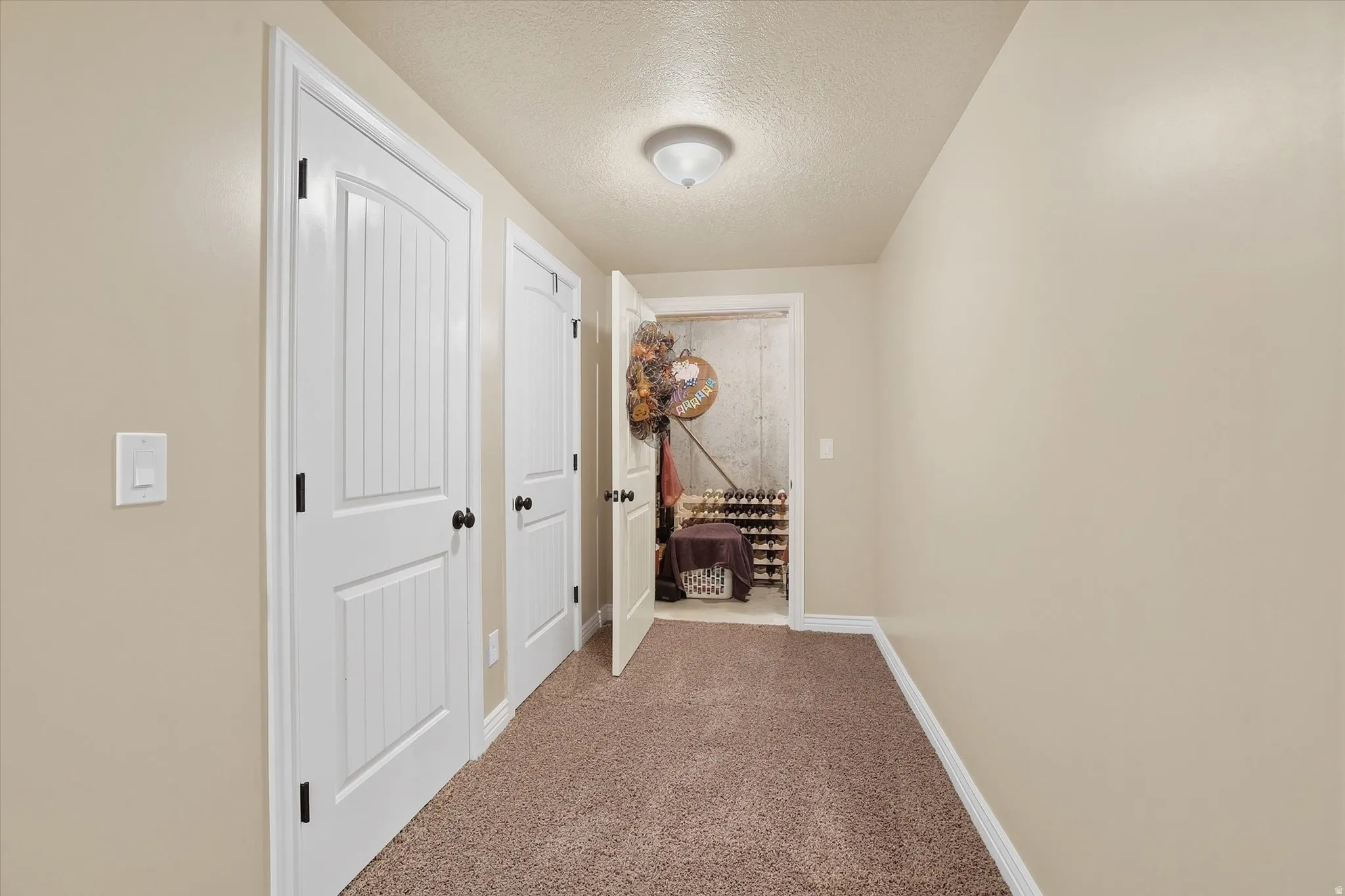 Corridor featuring a textured ceiling and carpet flooring