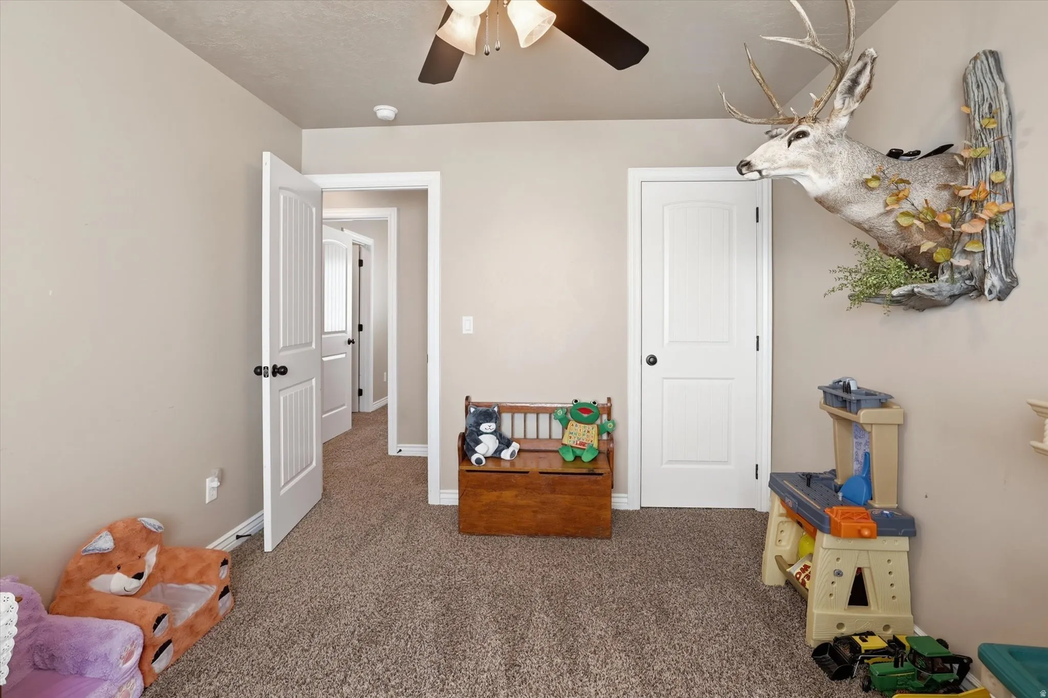 Playroom featuring ceiling fan and carpet floors