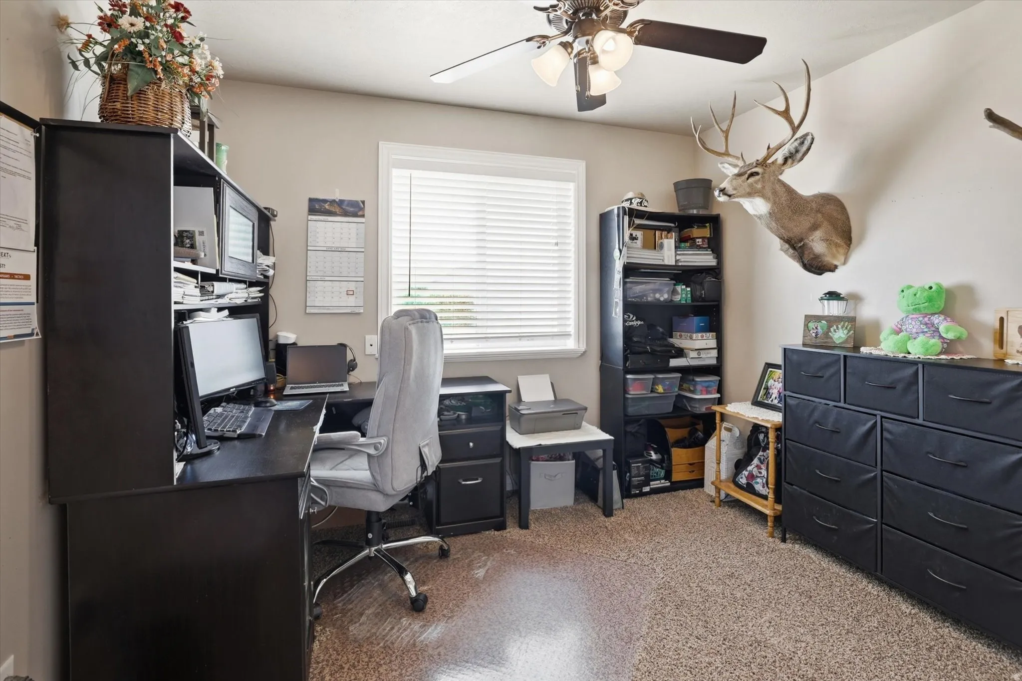 Home office featuring light carpet and ceiling fan