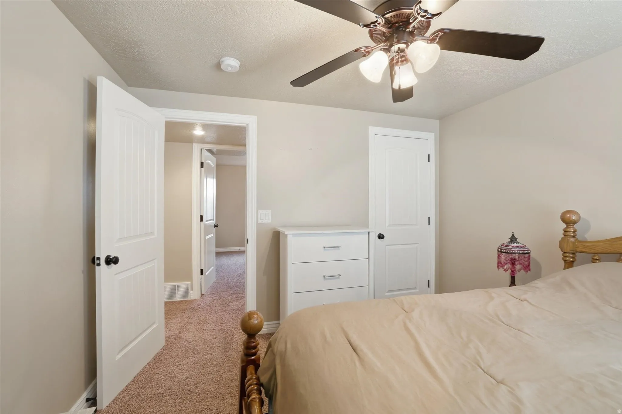 Bedroom featuring carpet floors, a textured ceiling, and ceiling fan
