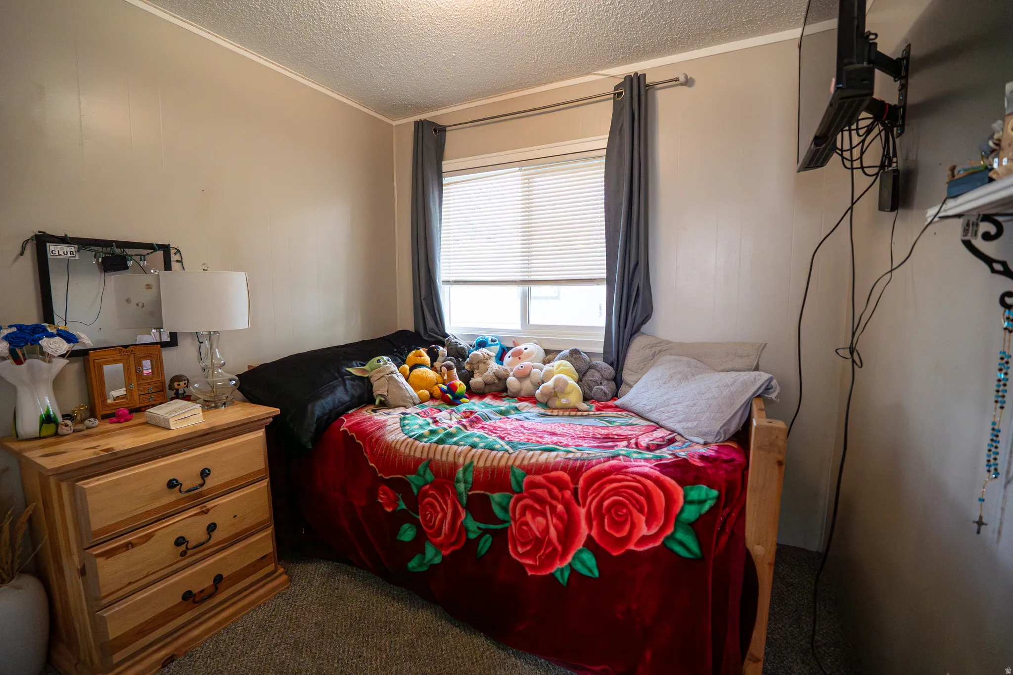Carpeted bedroom with ornamental molding and a textured ceiling