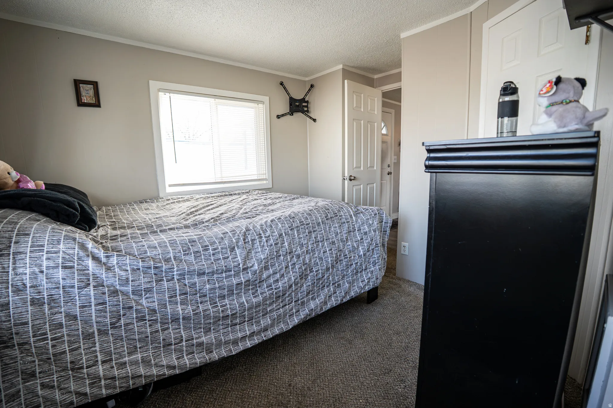 Bedroom with carpet flooring, a textured ceiling, and ornamental molding