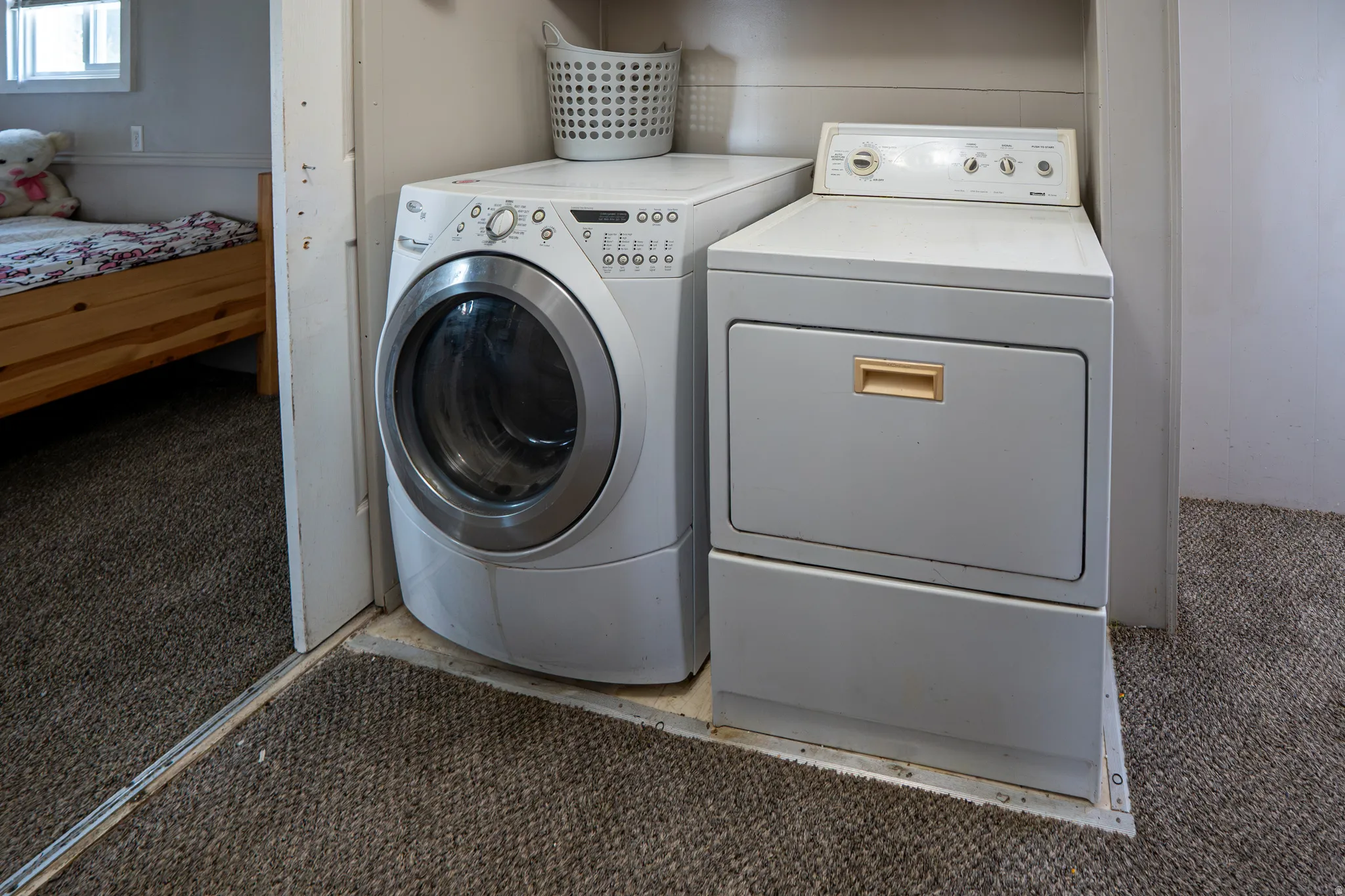 Laundry area with carpet flooring and washing machine and dryer