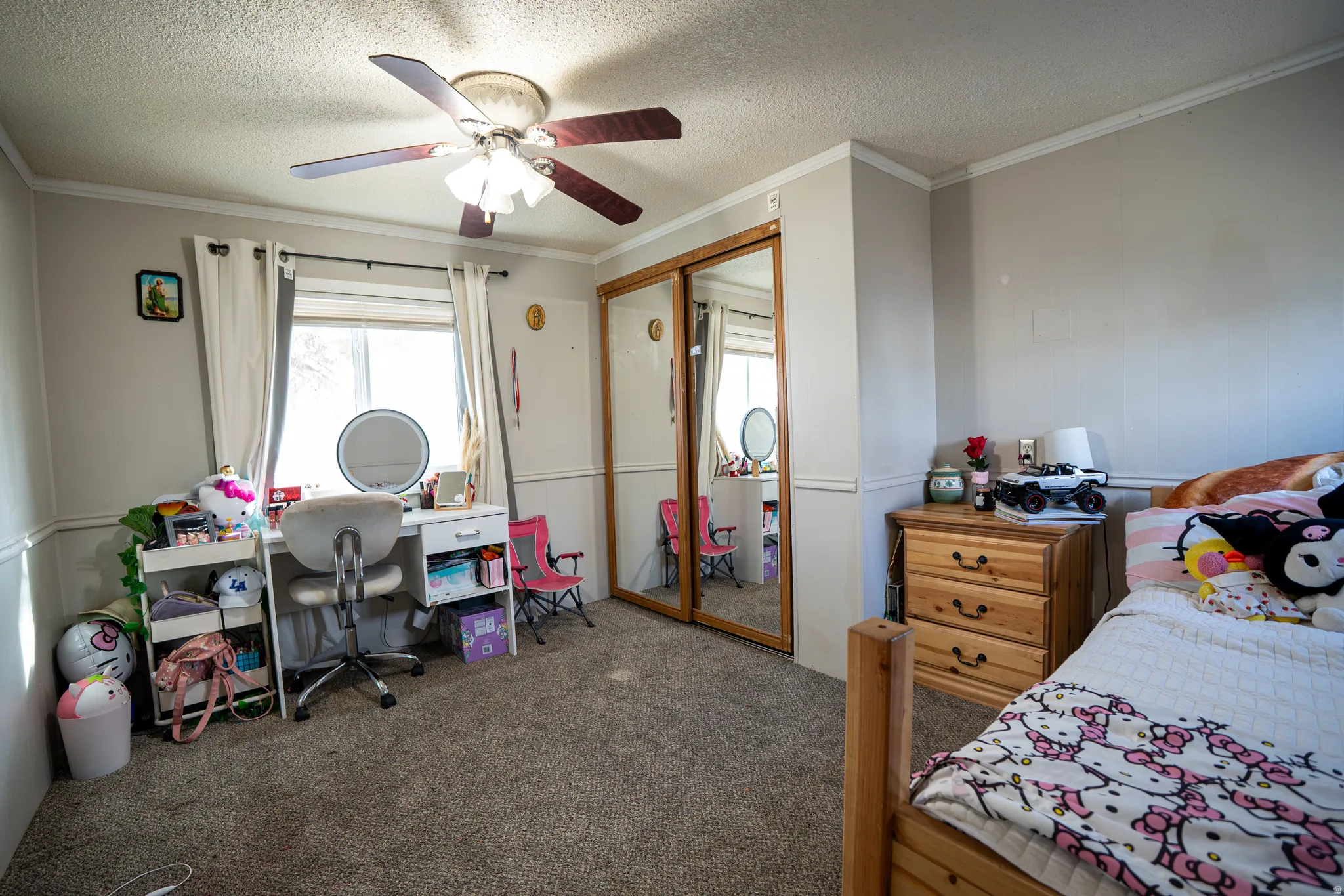 Bedroom with carpet, a closet, ceiling fan, a textured ceiling, and crown molding
