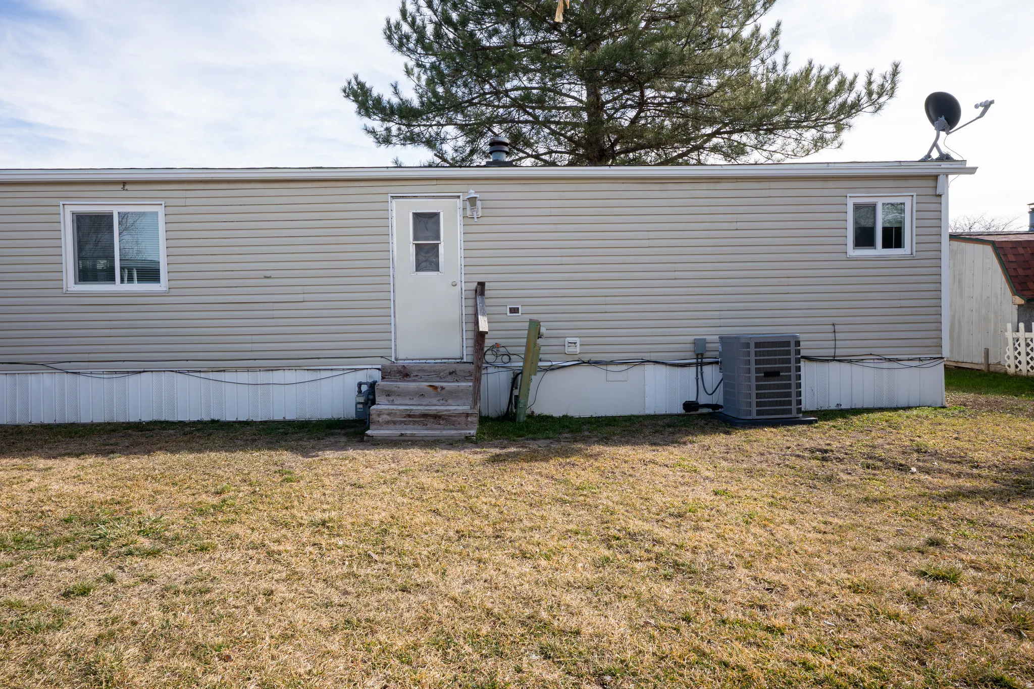 Back of house with a yard and entry steps
