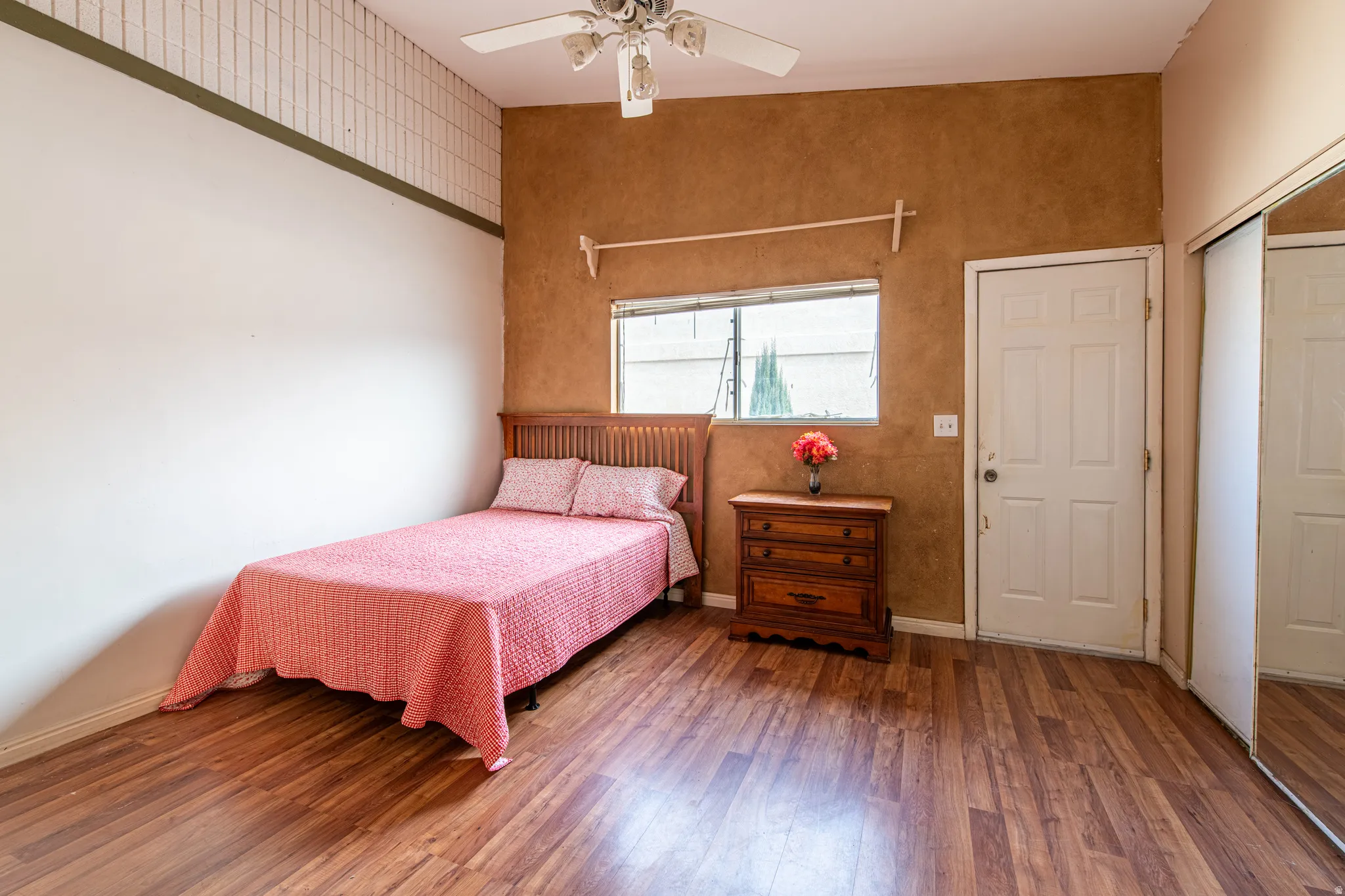 Bedroom with wood finished floors, a ceiling fan, and a closet